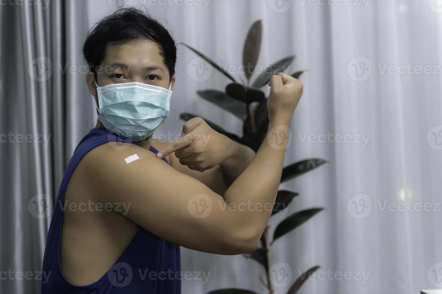 Asian handsome man showing vaccinated arm,Get vaccinated to protect against COVID-19,Antivirus corona virus concept photo