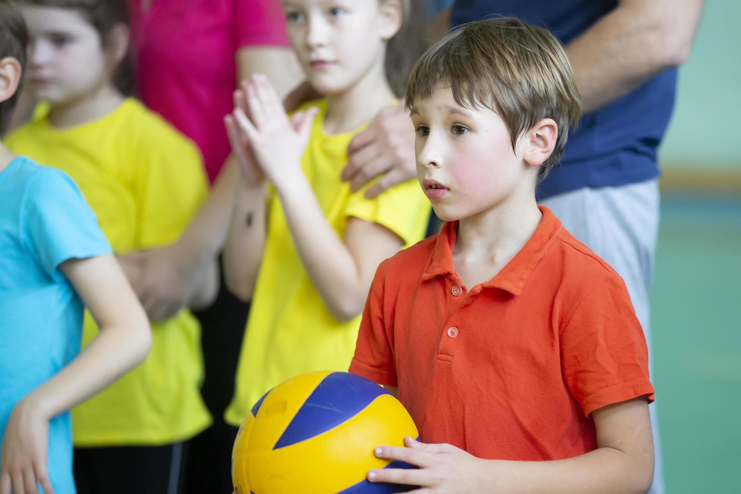 Child in the gym. A schoolboy with a ball in a physical education lesson. The boy in a sports uniform. Children's training. Sports Day. photo