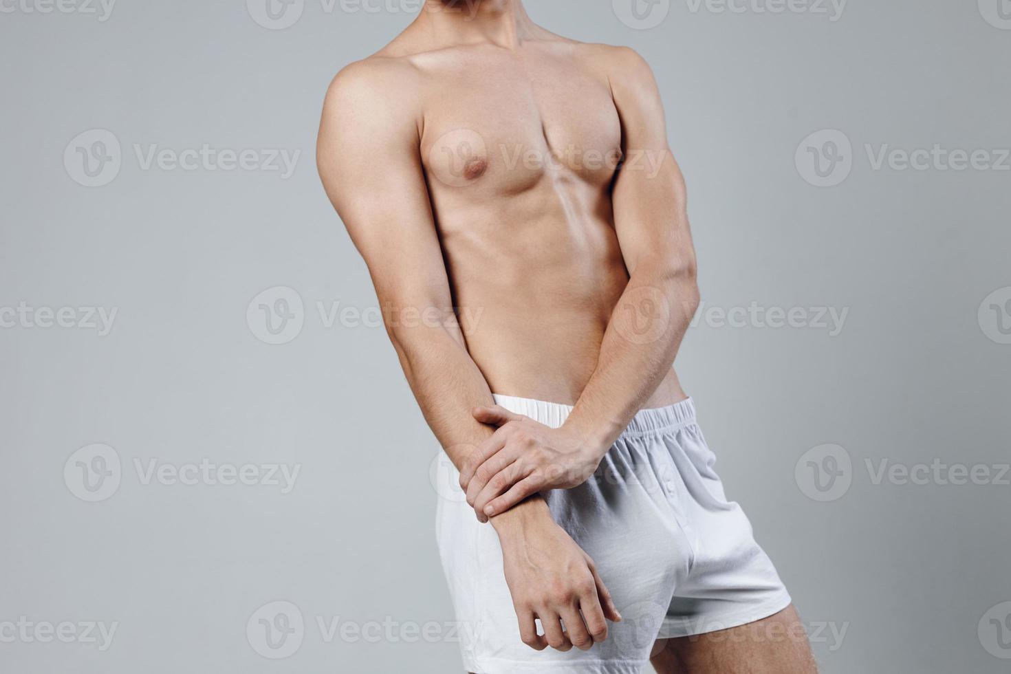 athlete with torso figure bodybuilder gray background white shorts cropped view photo