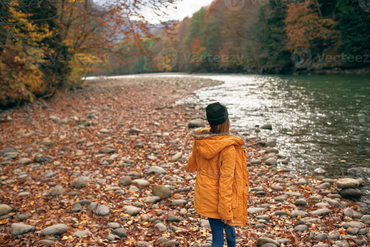 mujer caminando en el bosque a lo largo el río otoño viaje foto