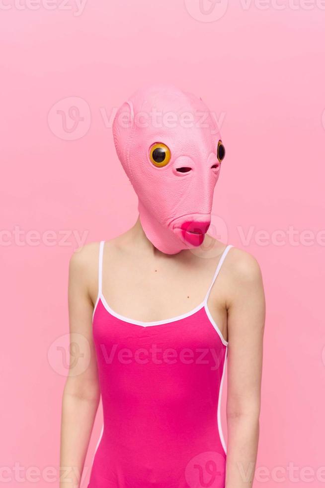 Modern Halloween costume in a silicone mask in the shape of a pink fish head in a sexy costume. The concept of a crazy look photo