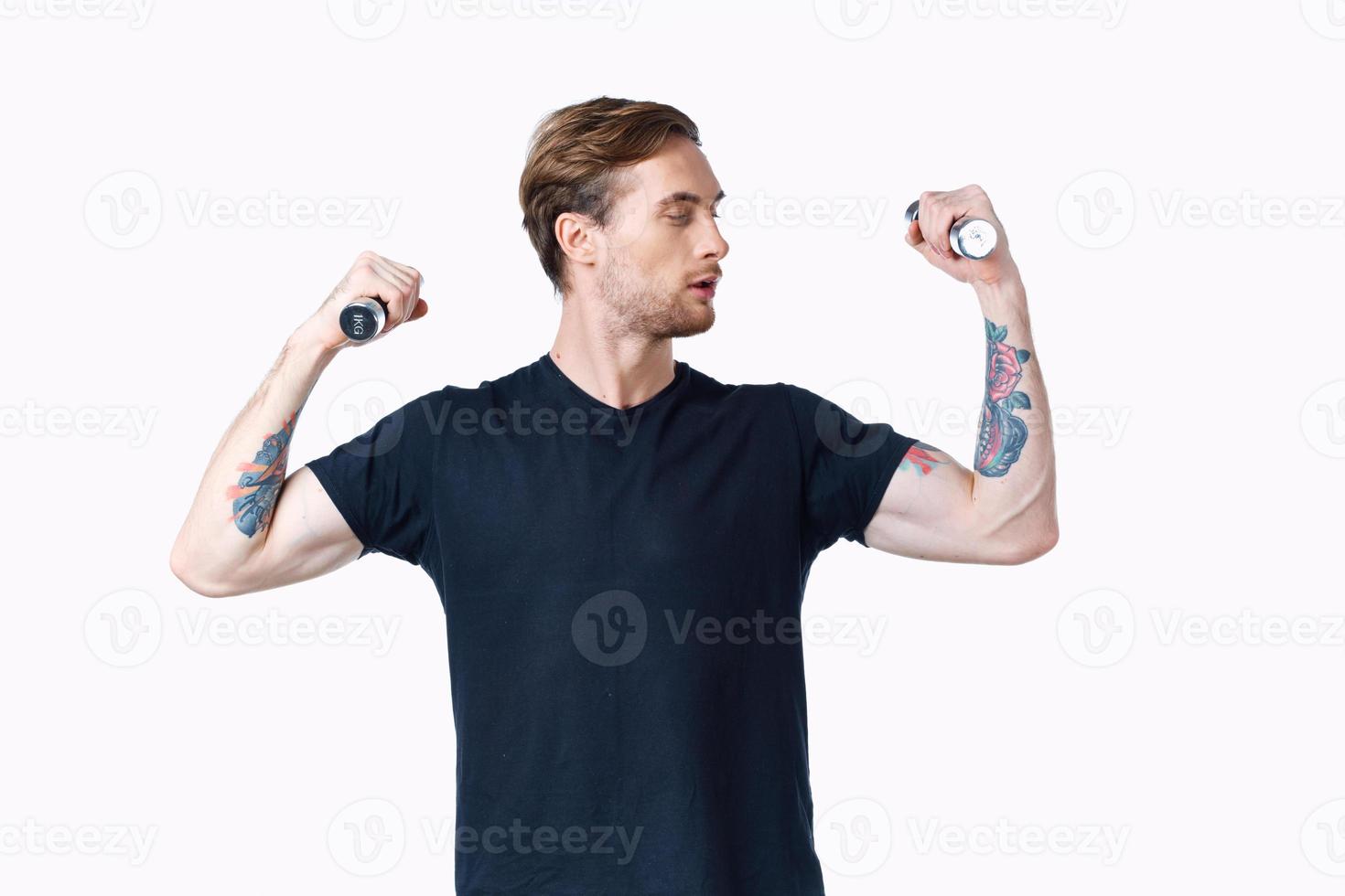 man with pumped up muscles of arms and dumbbells black t-shirt white background photo