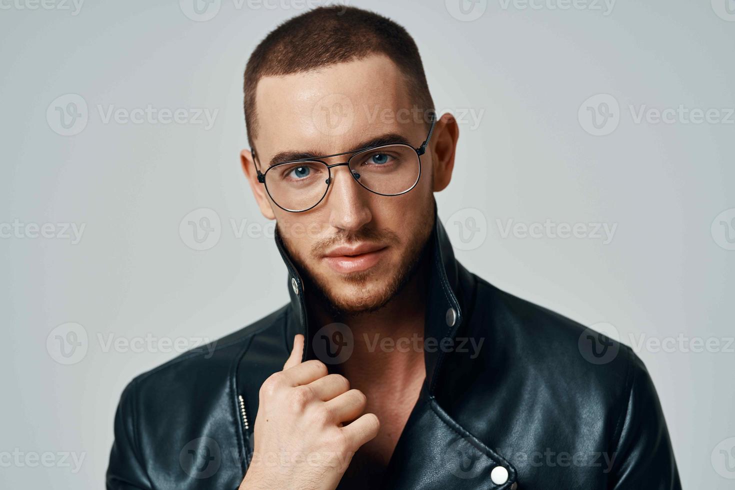 hermoso hombre vistiendo lentes corto pelo cuero chaqueta posando Moda foto