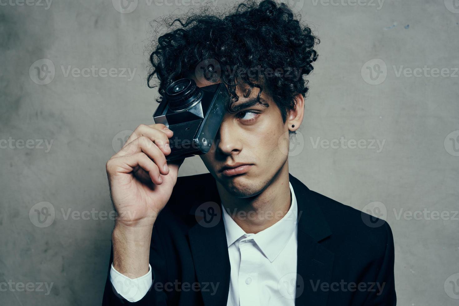 curly guy new technology camera studio gray background photo