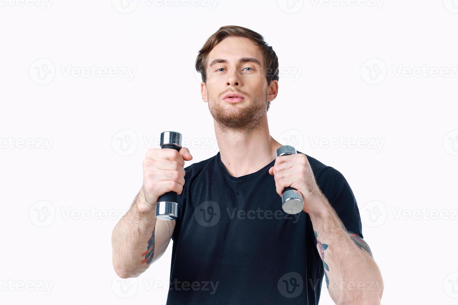 sports man is engaged in fitness on a white background with dumbbells in his hands photo