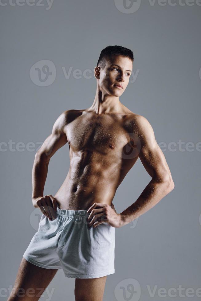 fuerte masculino atleta con flexionado brazo músculos en gris antecedentes foto