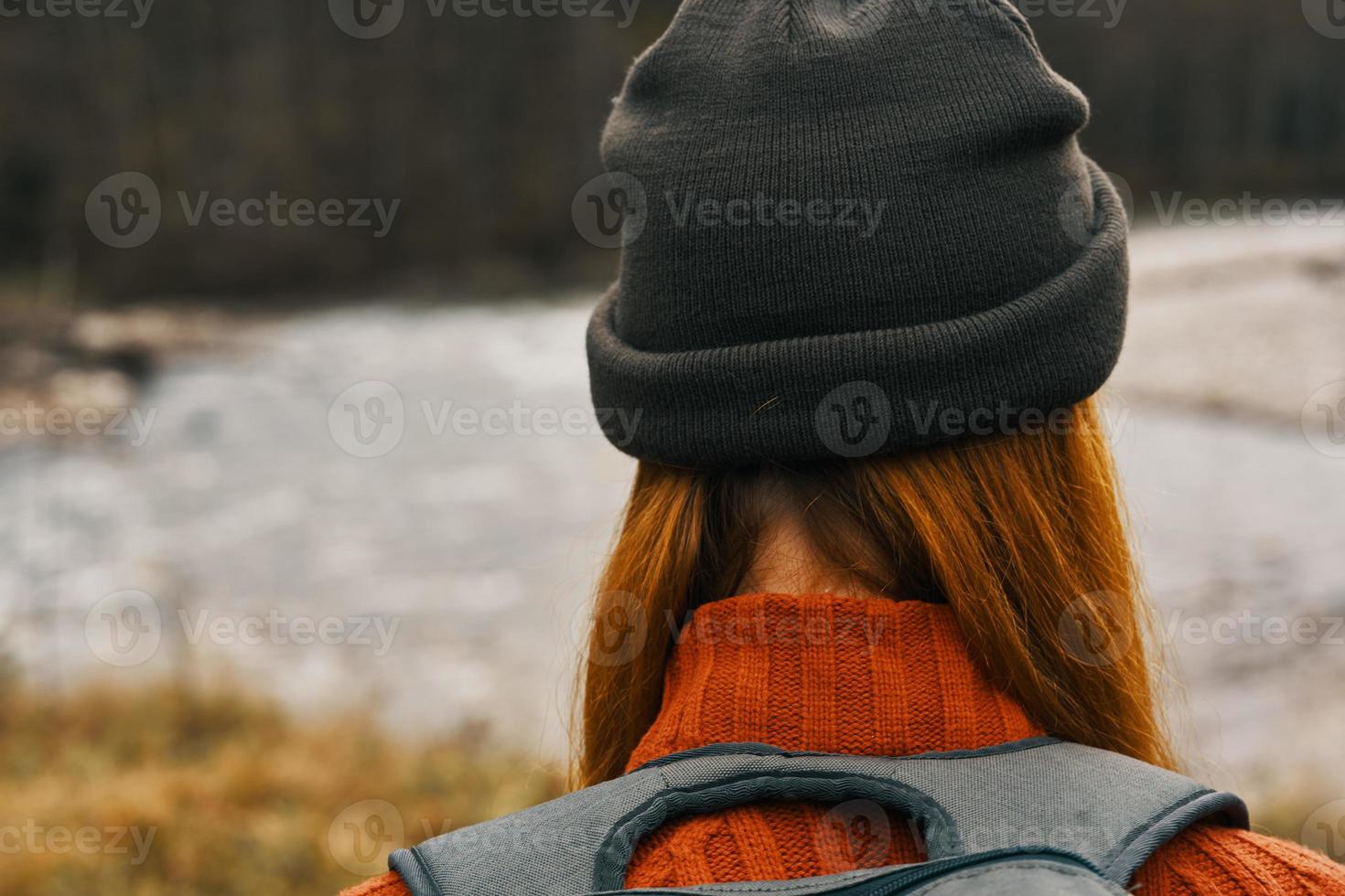 woman traveler walks in nature in the mountains near the river landscape model hat red hair photo