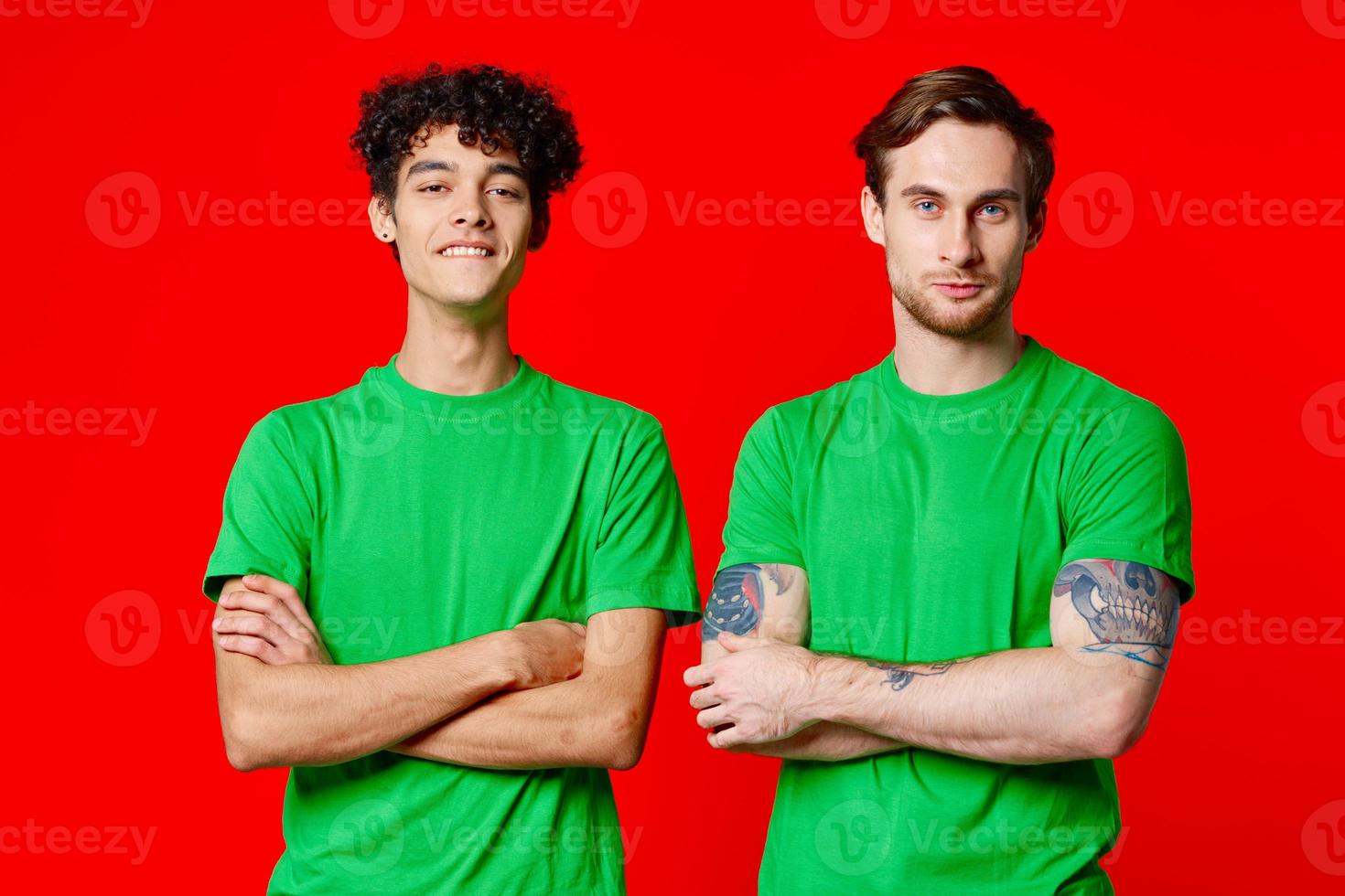 two men in green t-shirts are standing side by side communication photo