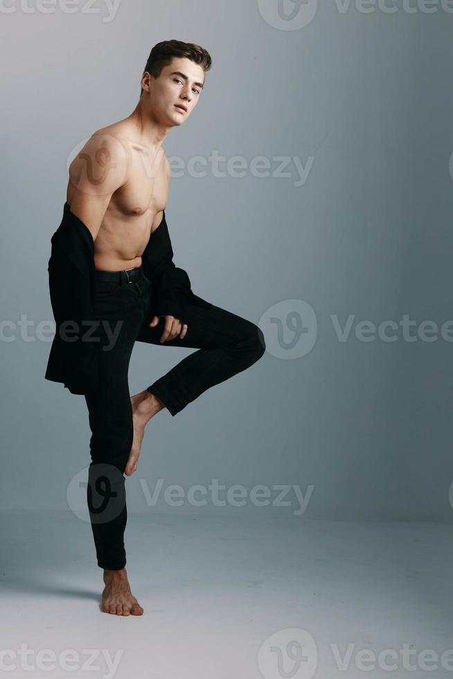 A man with a topless black trousers and a jacket gray background suit model photo