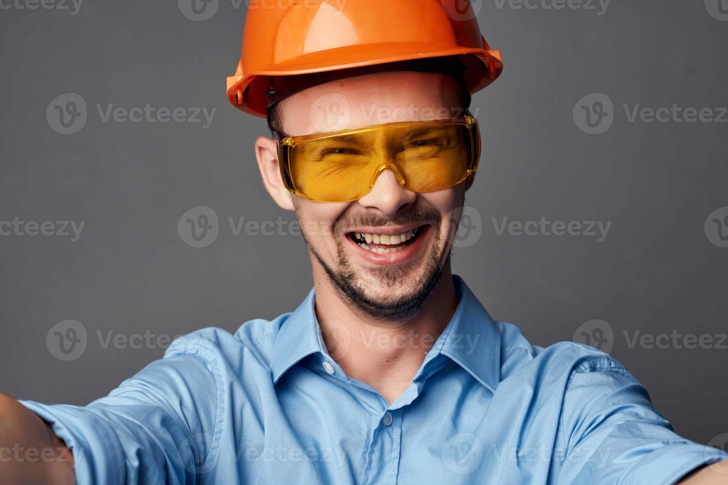 man wearing yellow glasses with orange paint safety work service photo