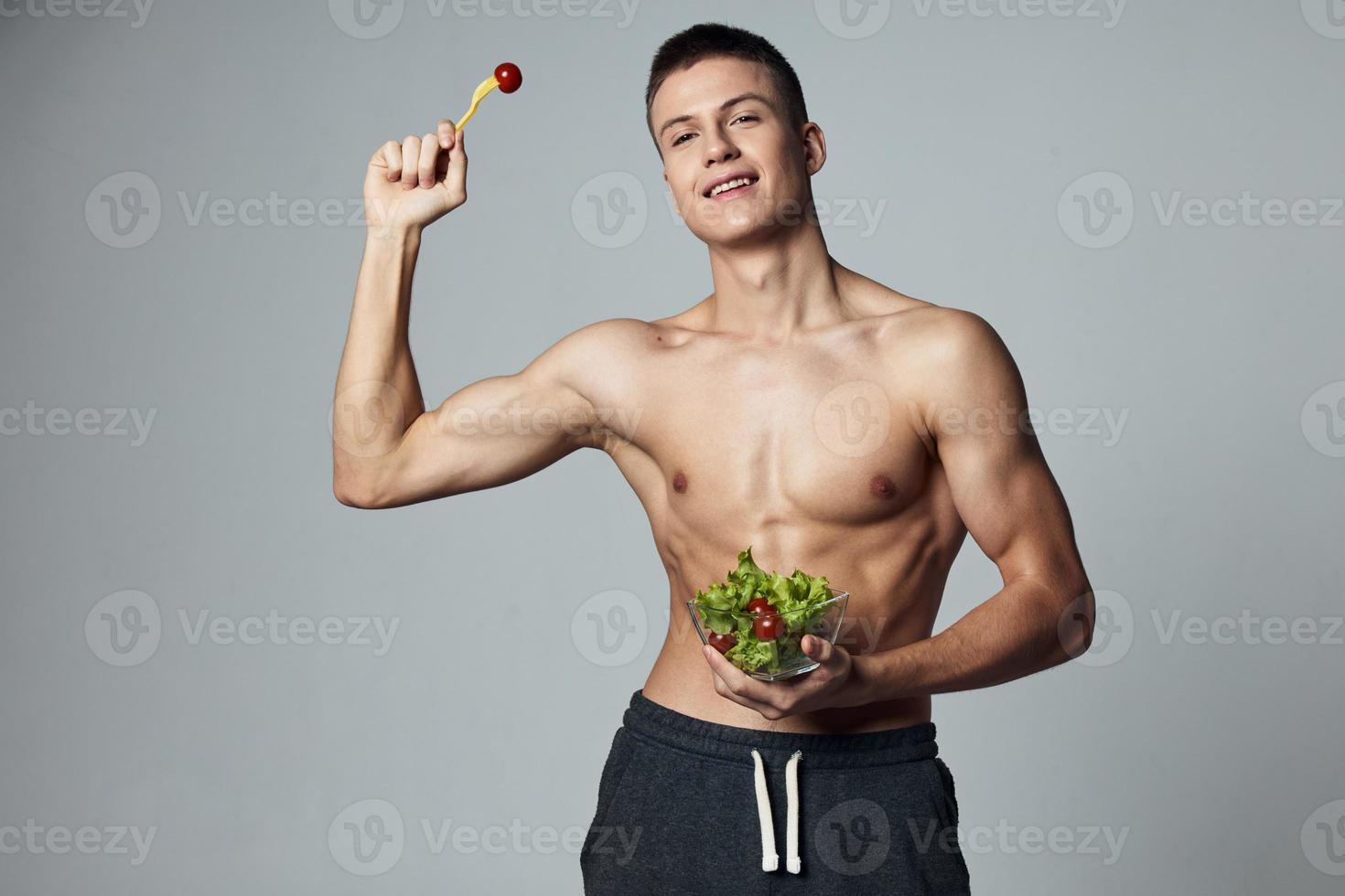 sports cheerful man with plate of salad energy diet food isolated background photo