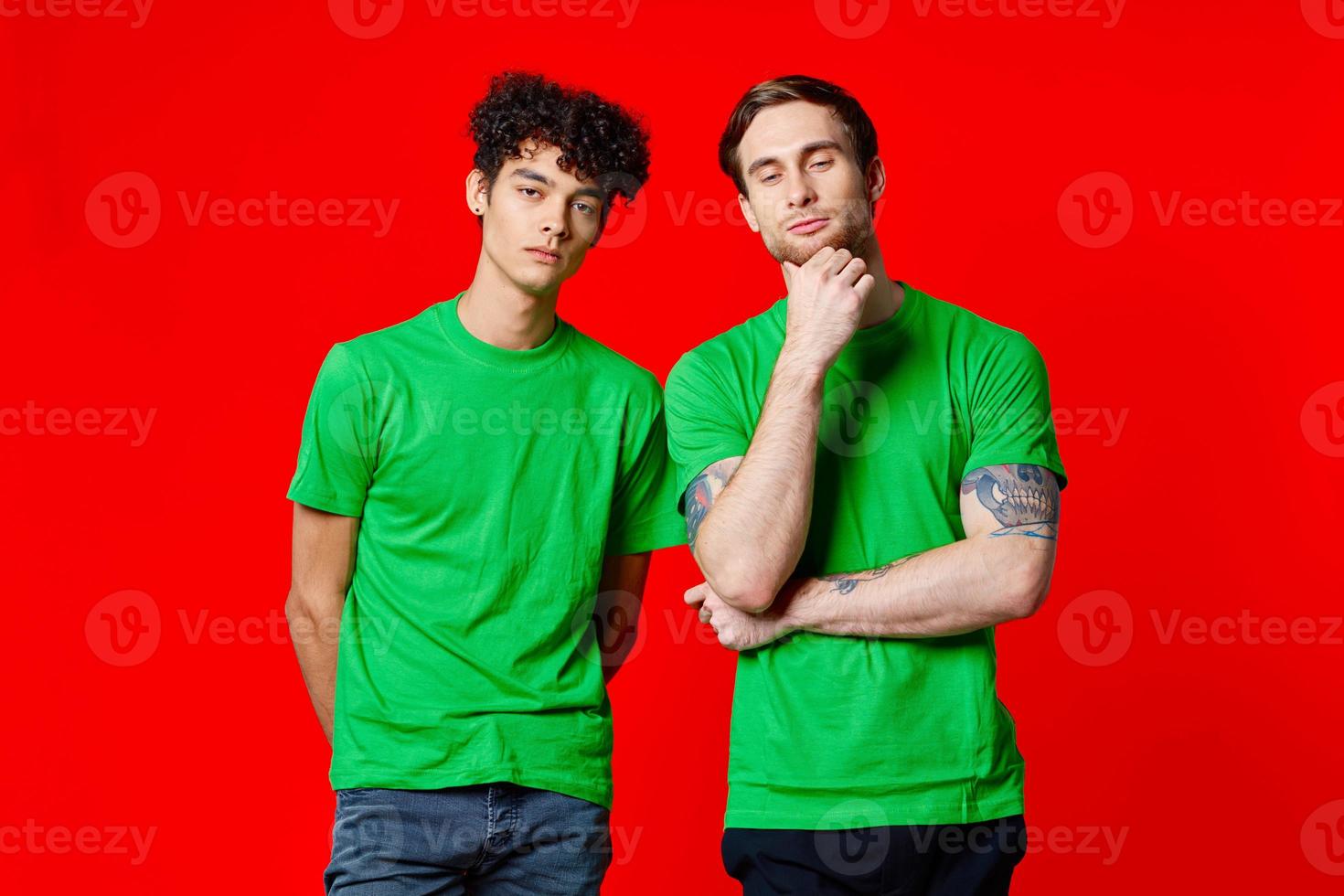 two friends in green t-shirts communication lifestyle red background photo