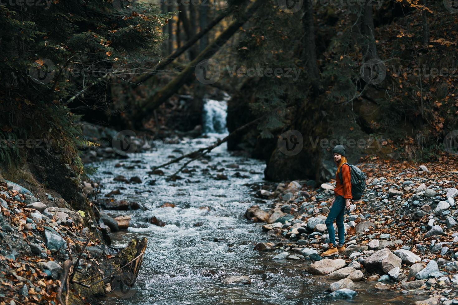 traveler with backpack landscape mountains transparent river pond and forest in the background photo