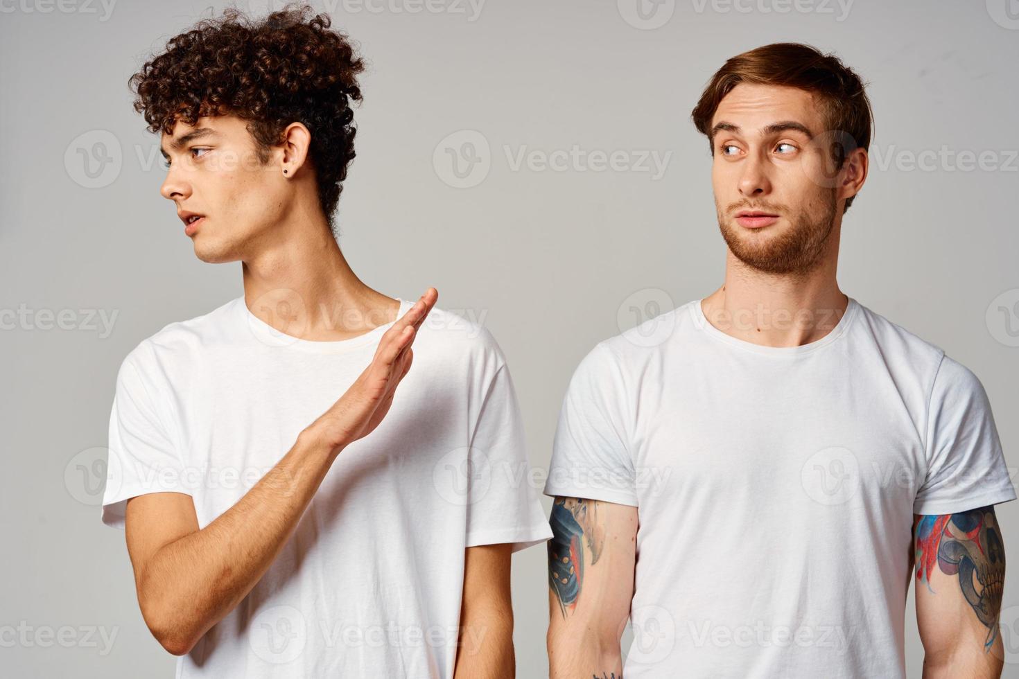 Two cheerful friends in t-shirts stand side by side isolated background joy photo