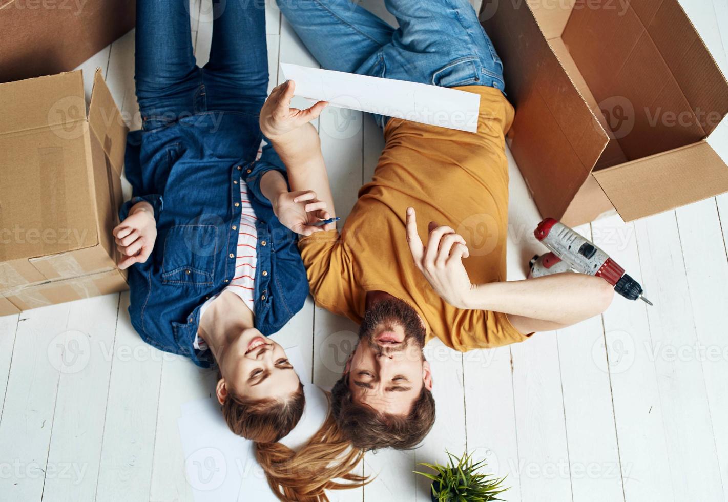 a mujer hombres en un de madera piso con cajas y un flor en un maceta foto