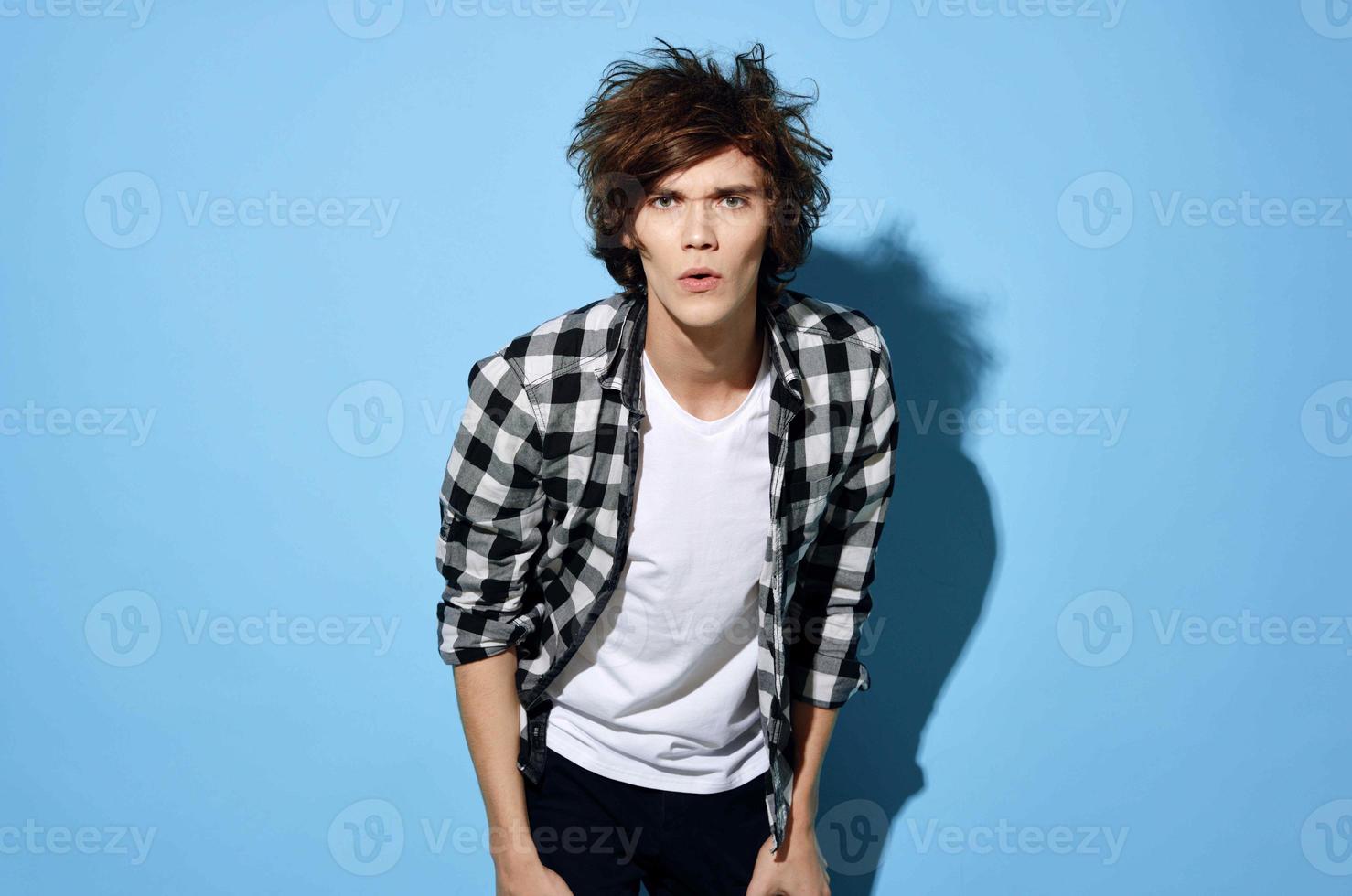 handsome young man with tousled hair plaid shirt posing photo