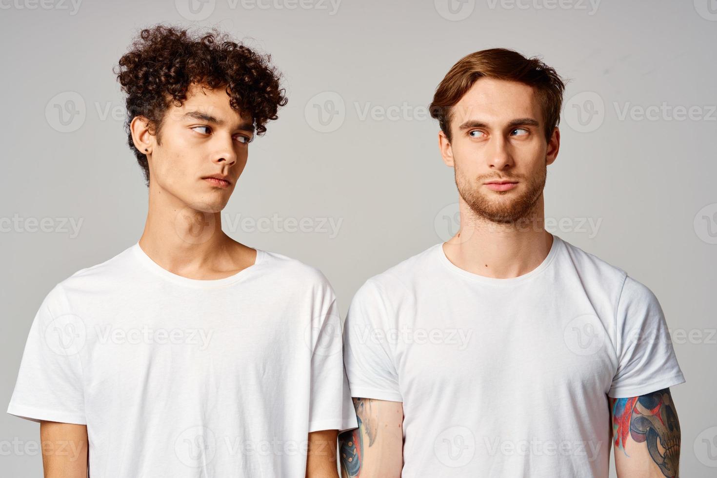 two men in white t-shirts are standing next to friendship emotions photo