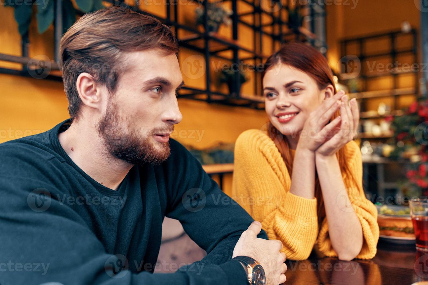 man and woman are sitting in a cafe at the table and gesturing with their hands friends emotions fun interior photo