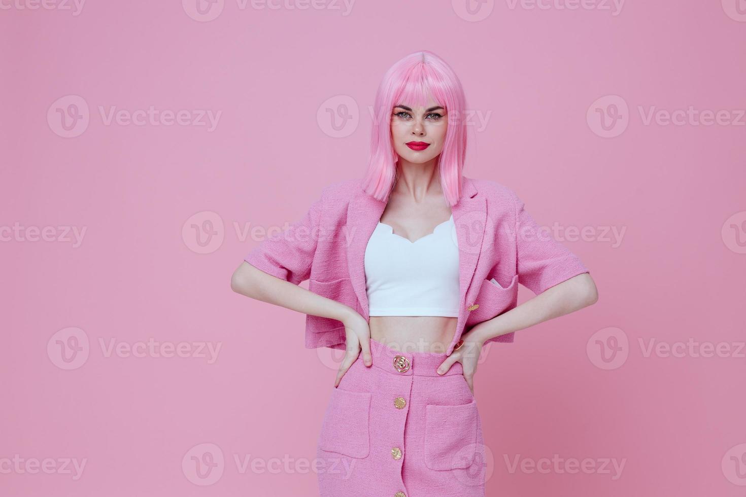 Positive young woman in a pink suit gesturing with his hands emotions fun pink background unaltered photo