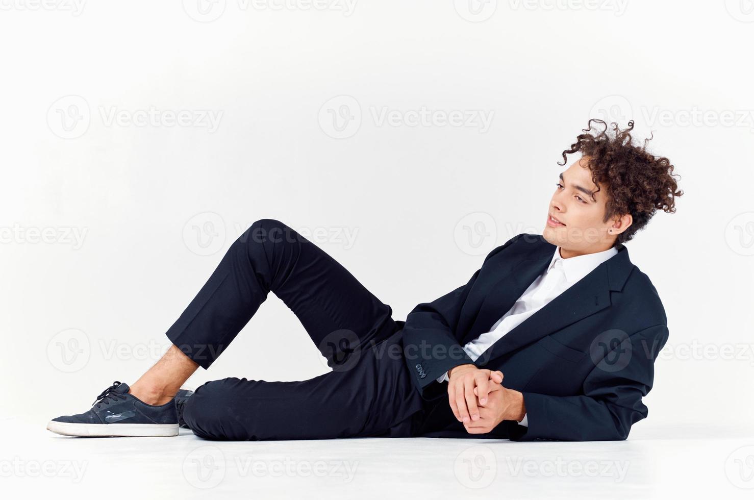 guy in trousers and a jacket lies on the floor In a bright room, photo