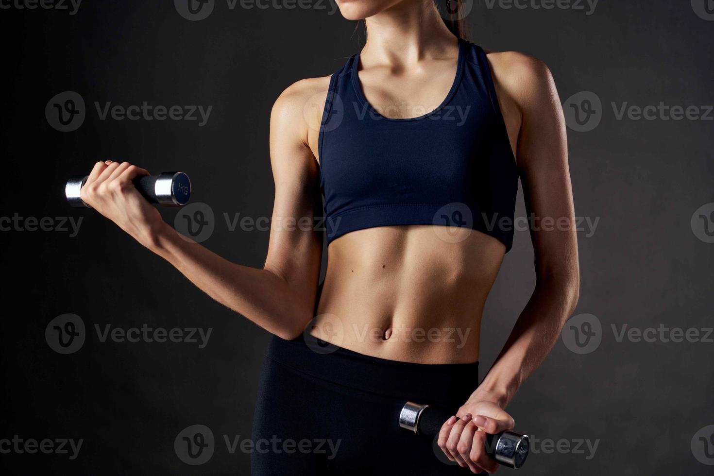 athletic woman with a slim figure with dumbbells in the hands of fitness workout photo