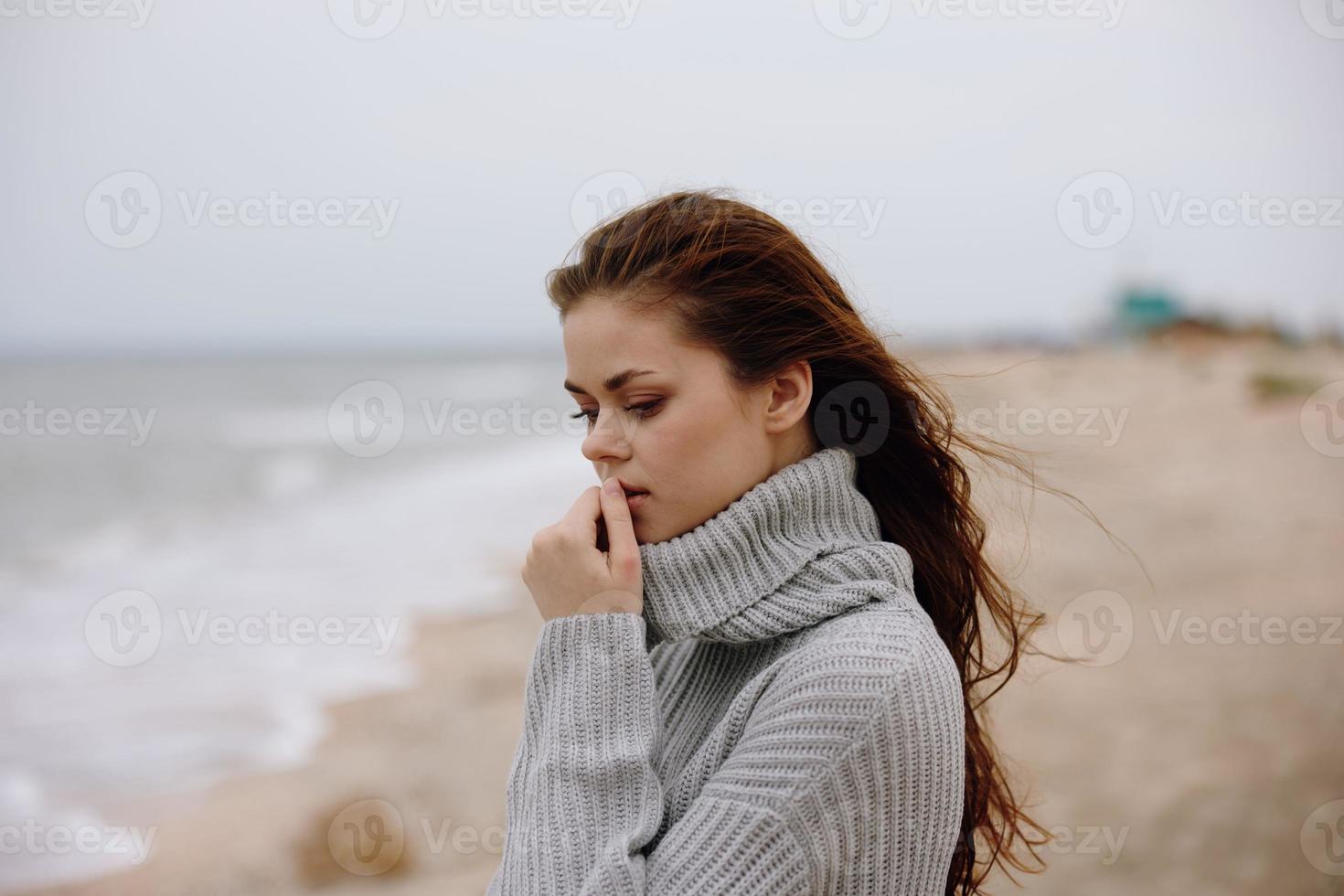 portrait of a woman red hair in a sweater by the ocean unaltered photo