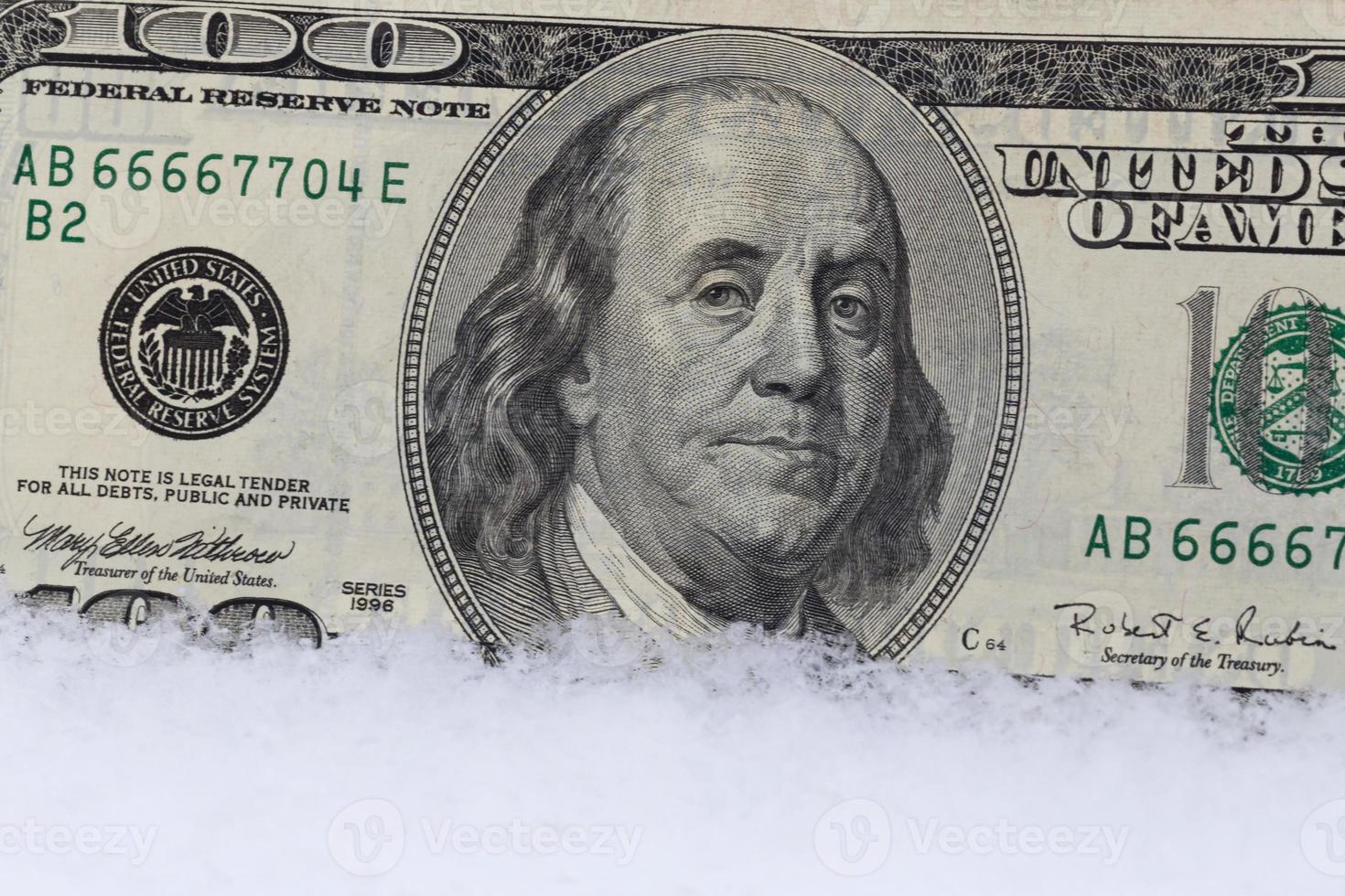 close up of one hundred dollars banknote in snow photo