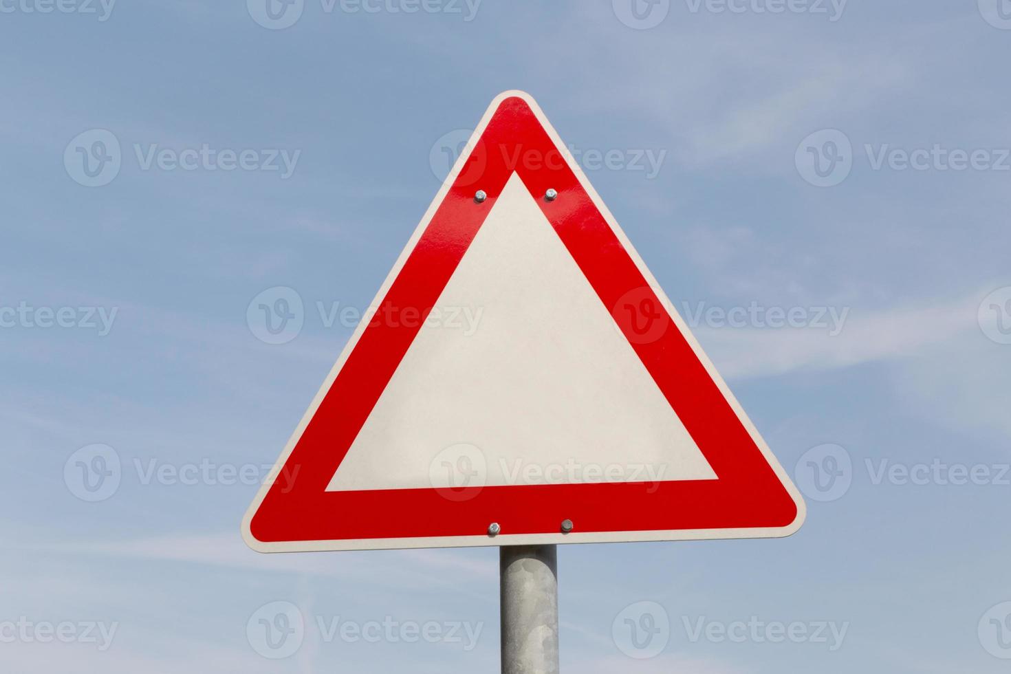 blank warning road sign against blue sky photo