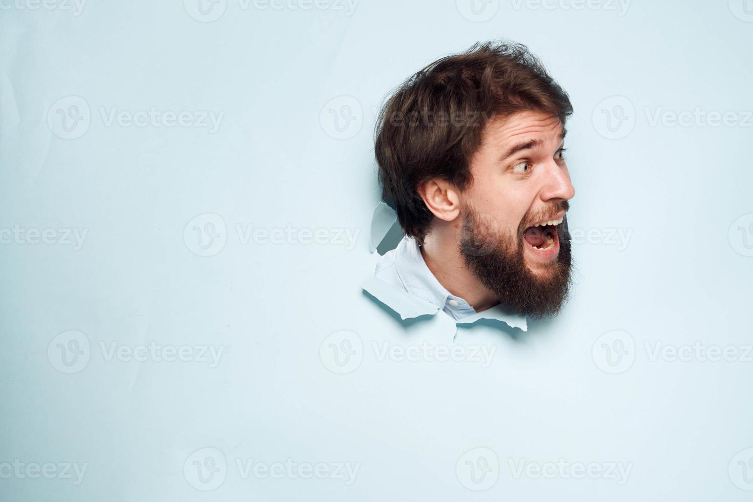 A disgruntled man looks out from behind the wall of the office manager's job photo