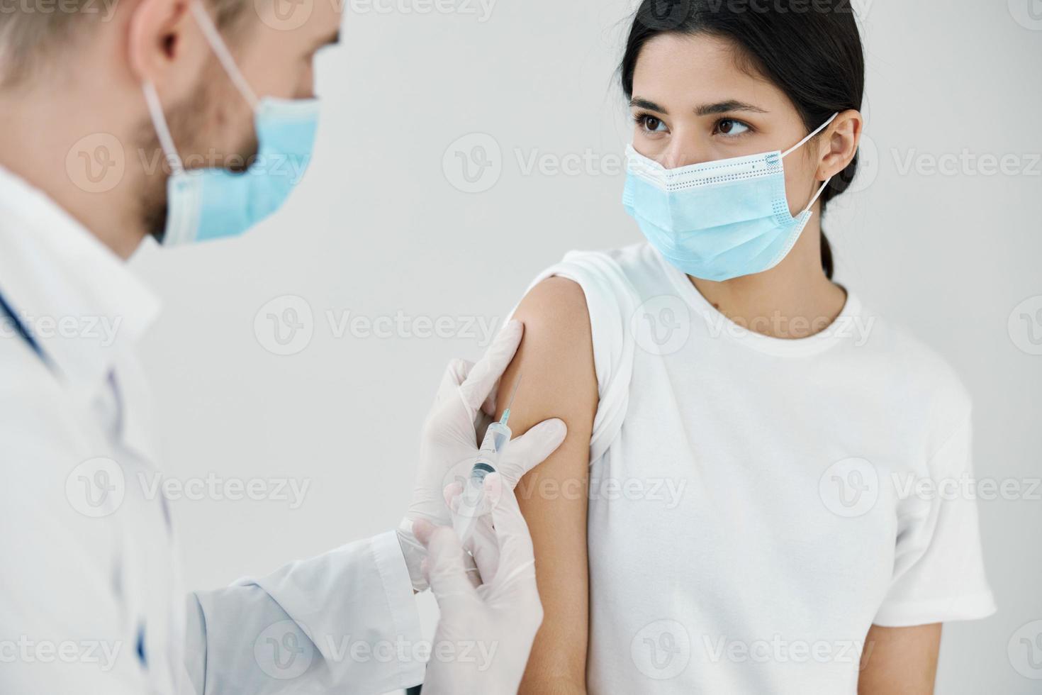 patient in medical mask in hospital and doctor vaccination injection photo