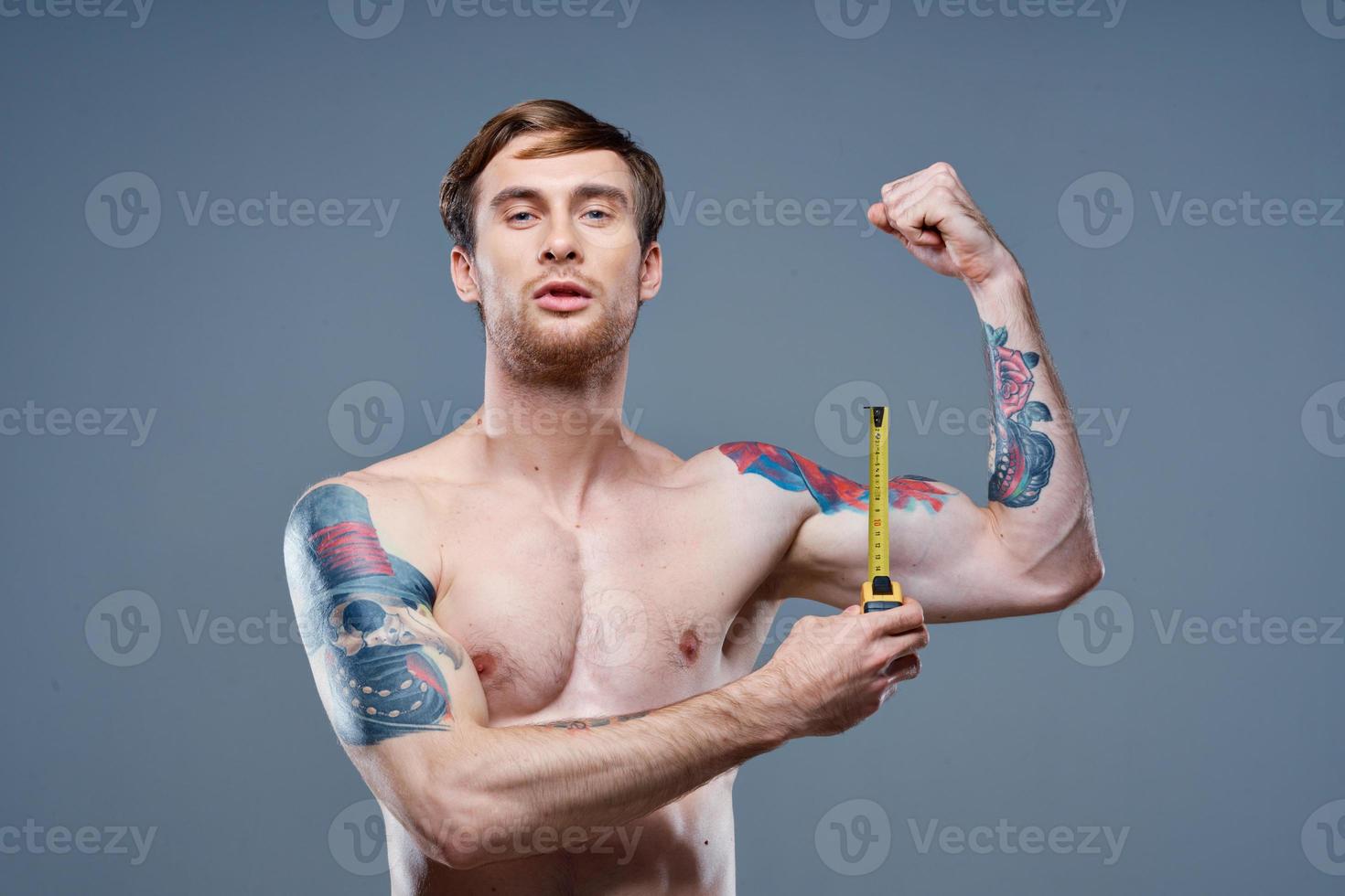 tattooed man muscular bodybuilder Fitness gray background photo