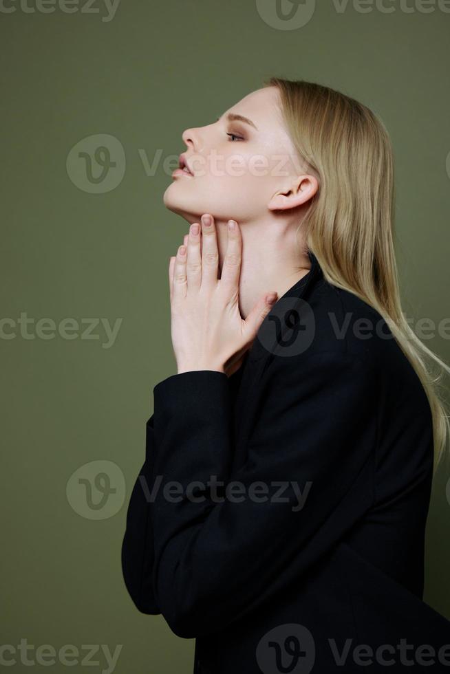 Stylish fashionable charming girl posing in profile looking to the side on a green olive background in the studio. Cool banner for brands photo