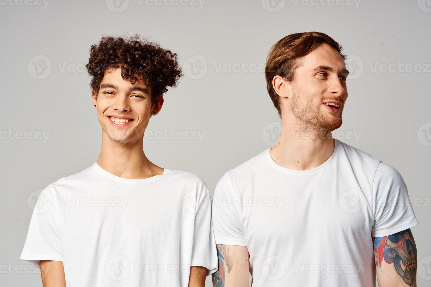 Two cheerful friends in t-shirts stand side by side isolated background joy photo