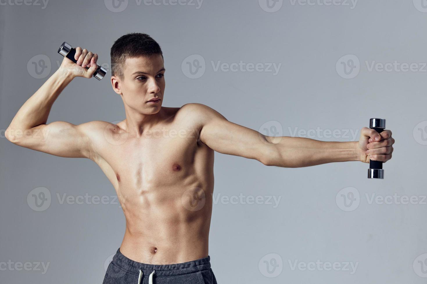 a man of athletic build with dumbbells in his hands pumped up press posing 22252461 Stock Photo