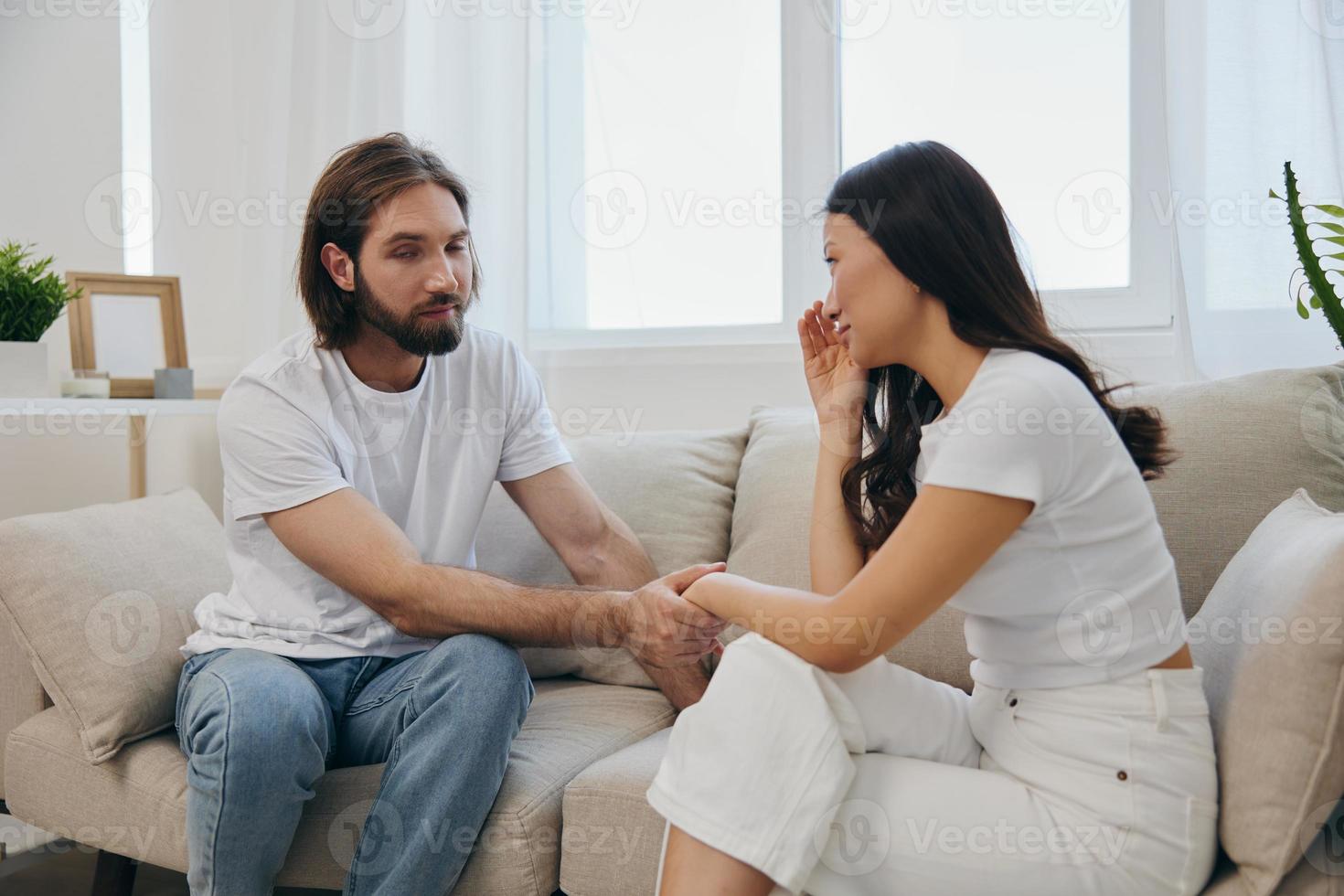 un asiático mujer es triste y llorando con su masculino amigo a hogar. estrés y malentendido en un relación Entre dos personas foto