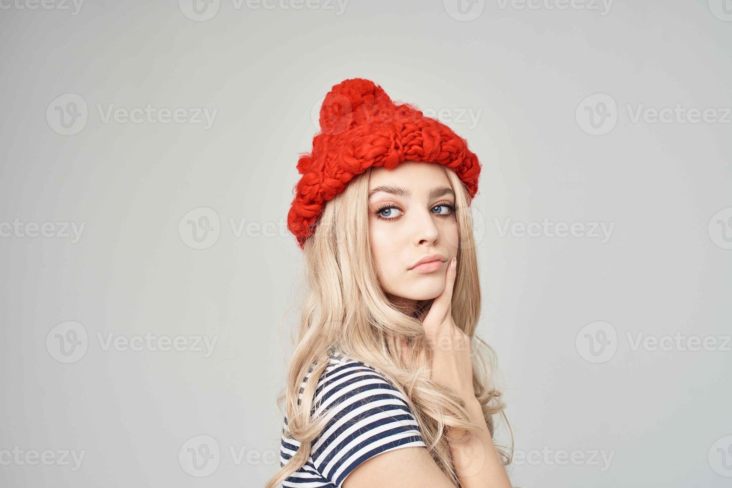 blonde in a striped T-shirt Red Hat light background Lifestyle photo