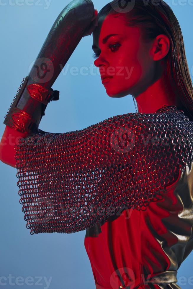 photo pretty woman Glamor posing red light metal armor on hand isolated background