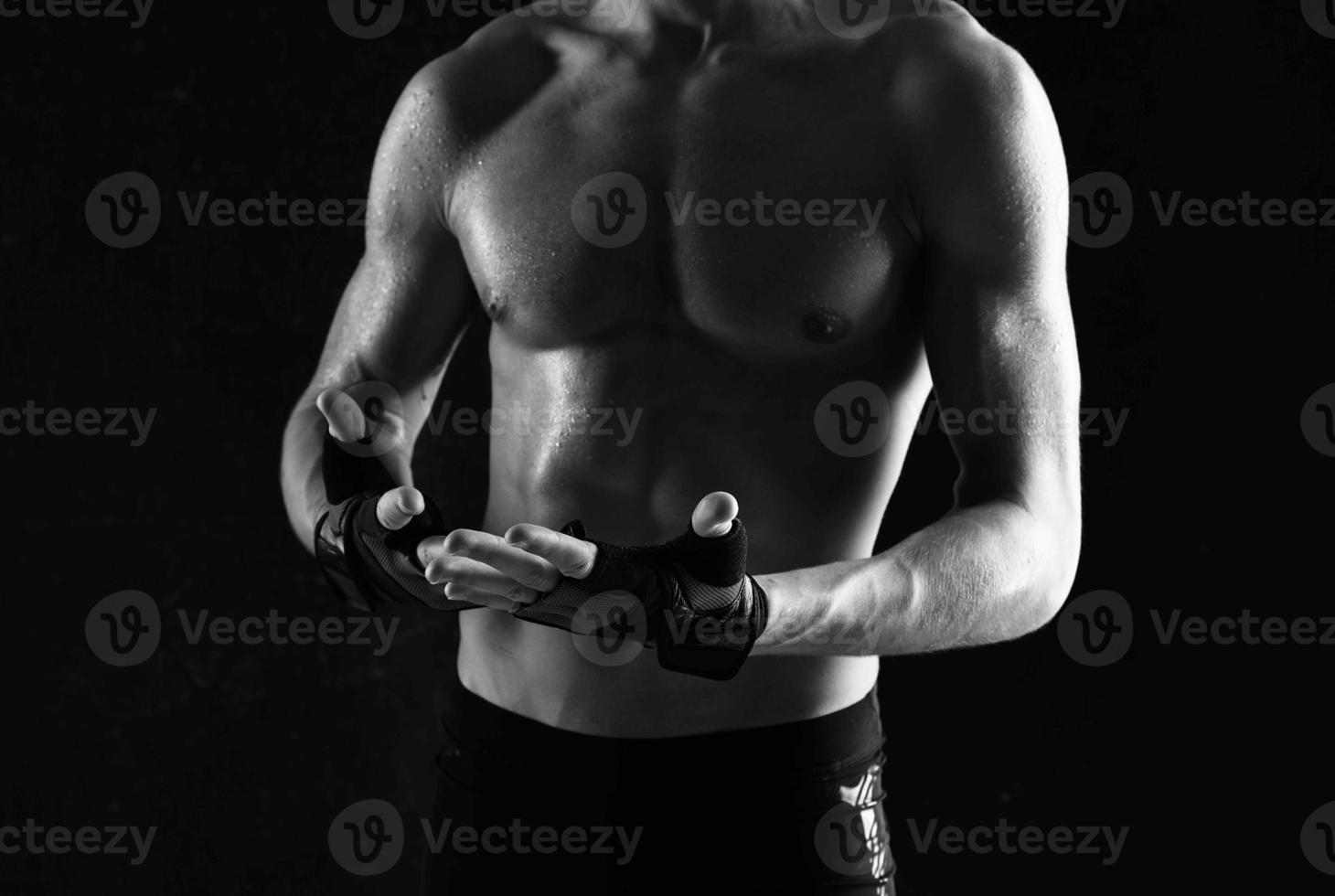 man with dumbbells in his hands naked muscular body workout dark background photo