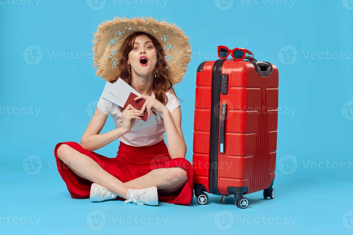 woman with red suitcase sitting on the floor passport and plane tickets lifestyle photo