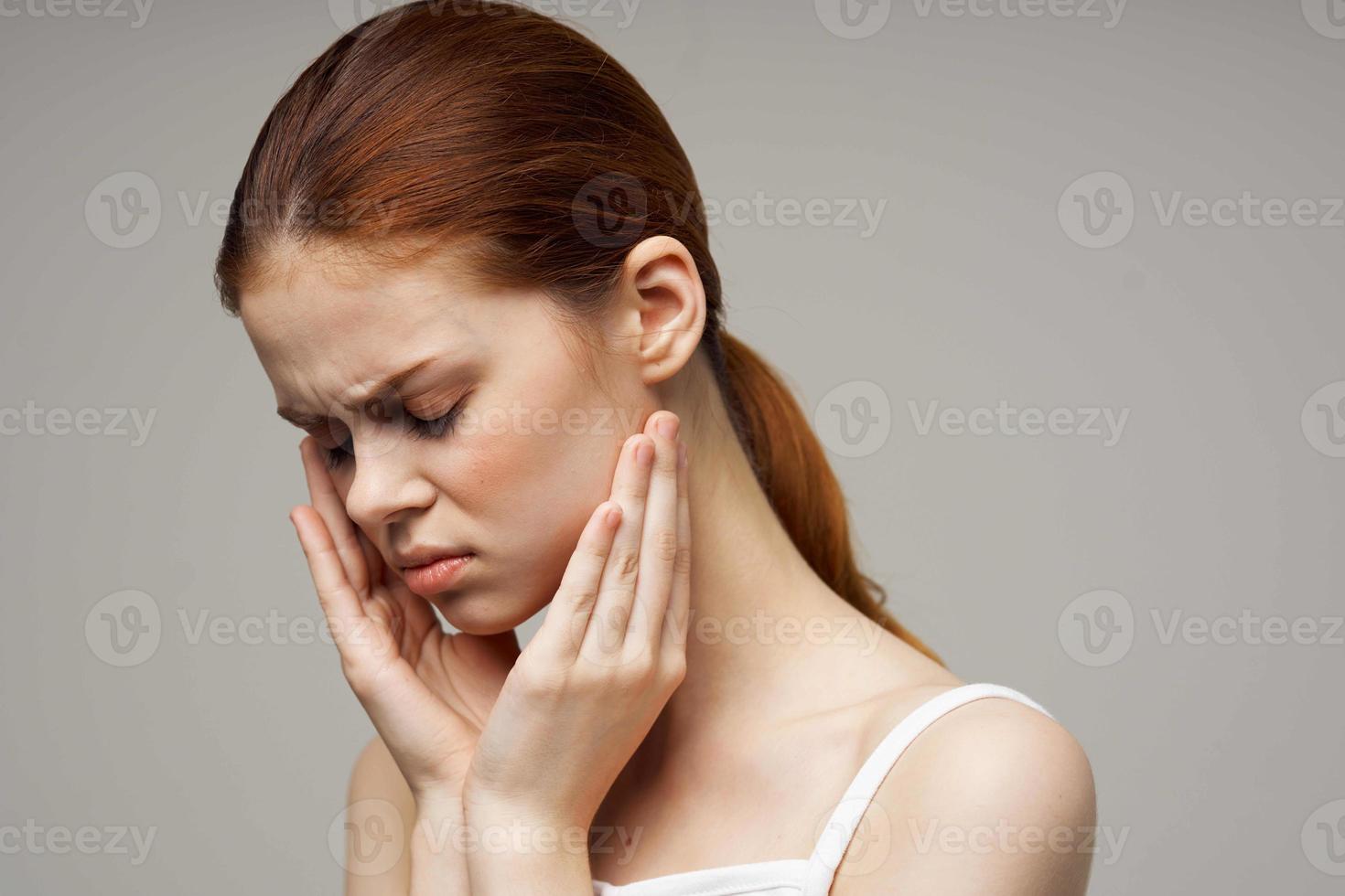 woman holding on to face pain in teeth studio treatment photo