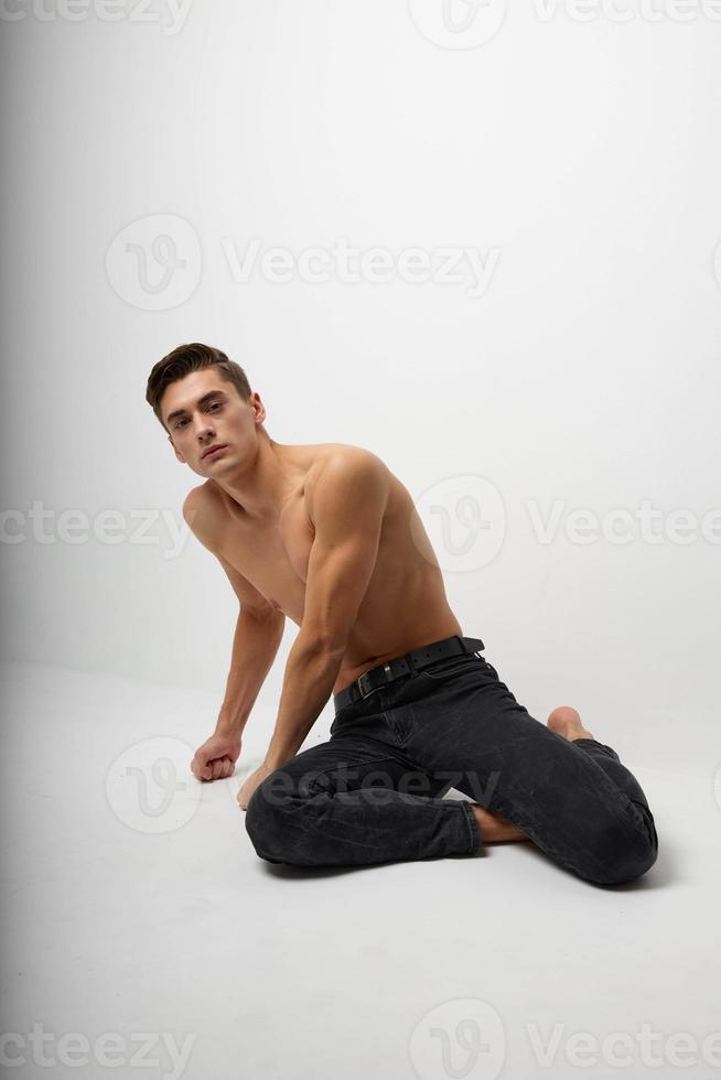 male topless sitting on the floor black pants model photo