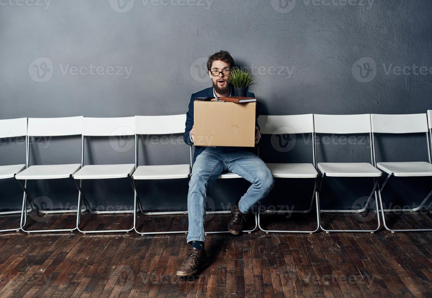 Man sitting on white chair waiting for lighting box job search depression photo