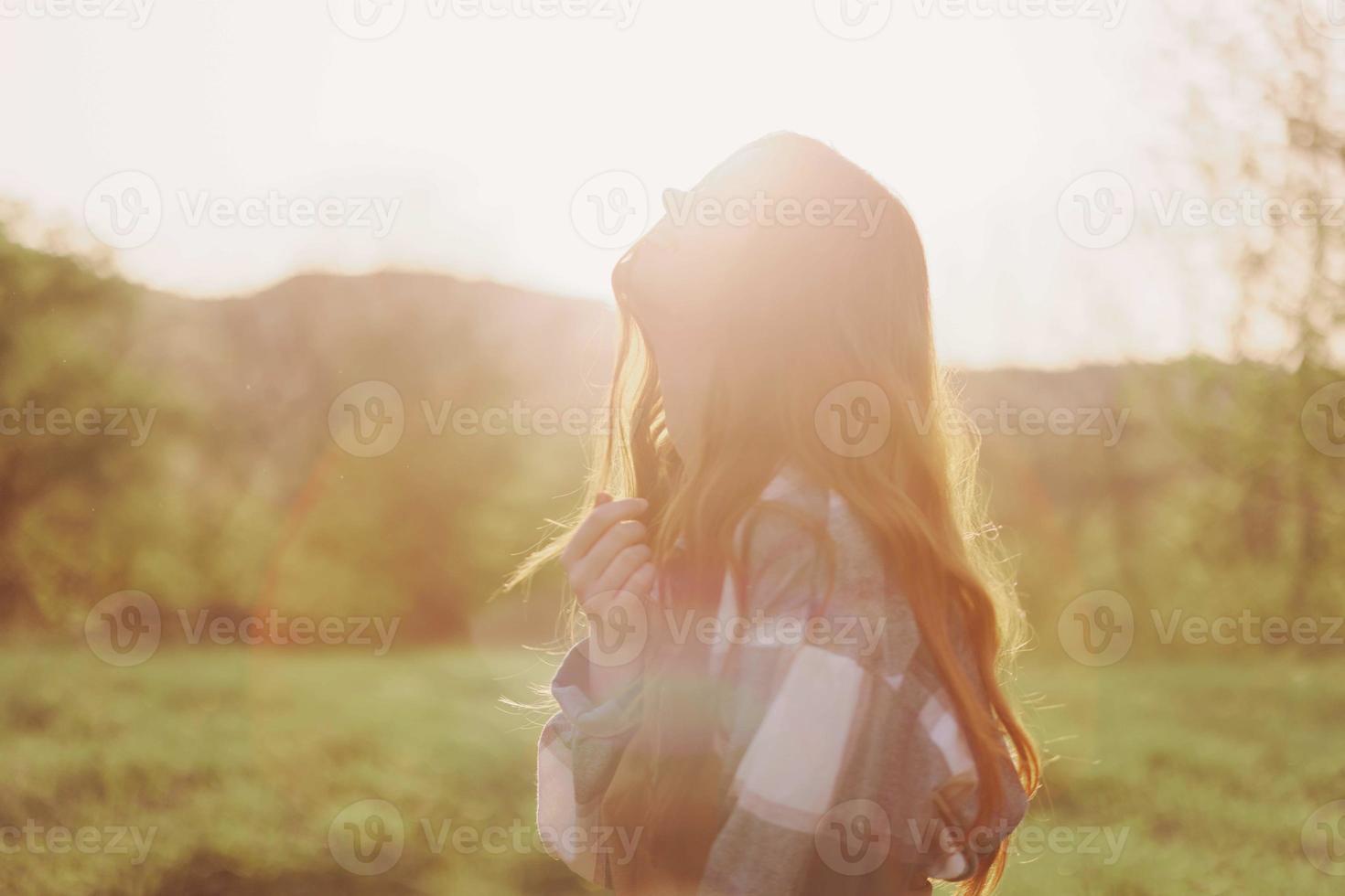 mujer sonriente en el antecedentes de puesta de sol luz de sol en naturaleza foto