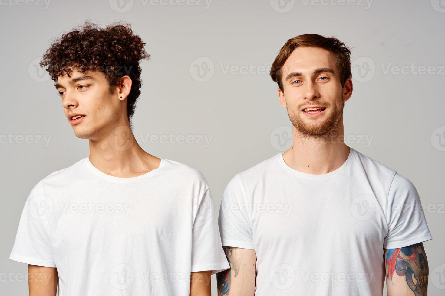 Two cheerful friends in t-shirts stand side by side isolated background joy photo