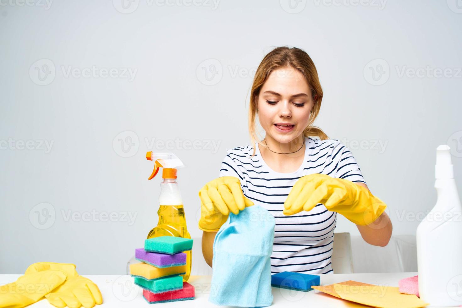 A cleaning lady sits at a table providing housekeeping services light background photo