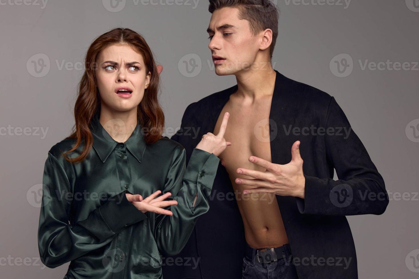 Conflict situation young people in suits on a gray background gestures with their hands problems in the family photo