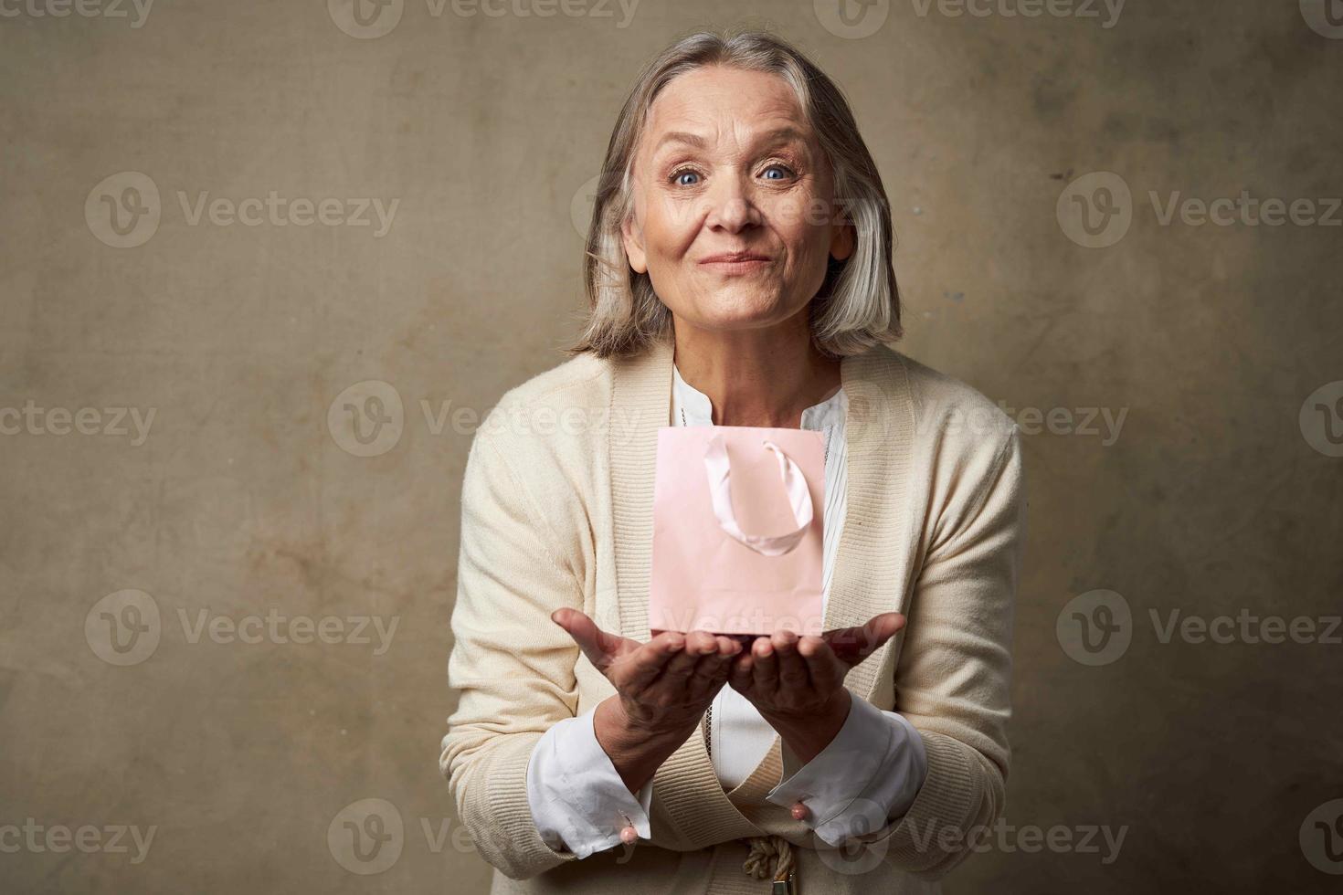 emotional elderly woman pink package gift care studio photo