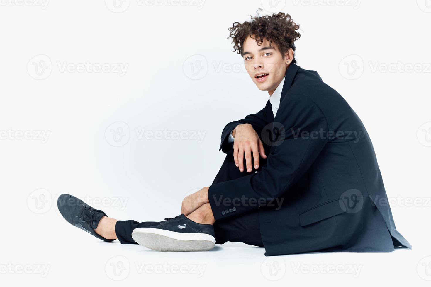 guy with curly hair in a suit sitting on the floor fashion self-confidence photo