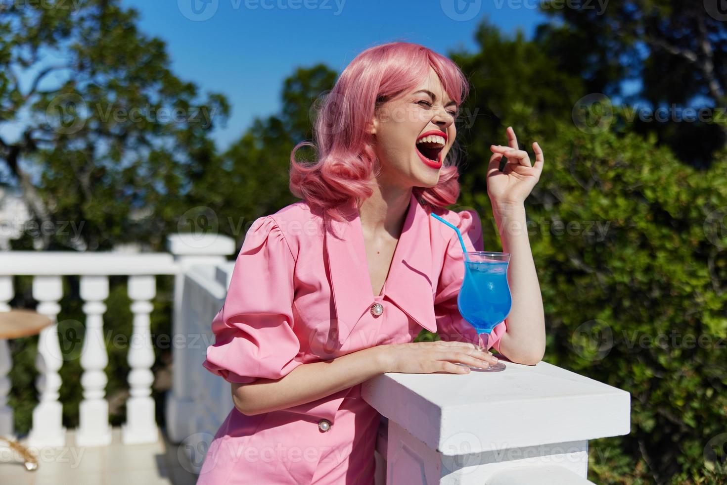 portrait of beautiful woman in pink dress outdoors with cocktail Summer day photo