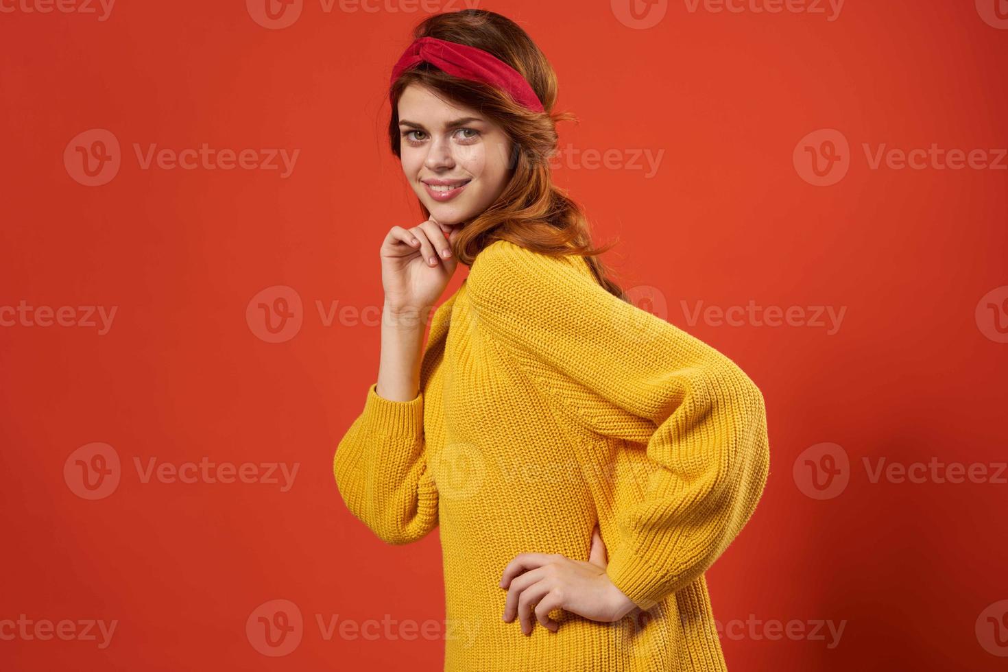 woman in yellow sweater with bandage on her head fashion red background studio photo